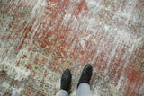 Distressed Mahal carpet with faded blush, ivory, and seafoam floral patterns beneath feet.