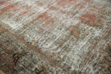 Distressed texture of the vintage Mahal carpet, blending faded blush, seafoam green, and soft ivory foundation.