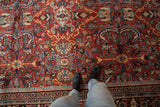 Vintage Mahal carpet detail: brick red field with sprawling plants, blue buds and scrolled leaves.