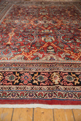 Intricate dark border of a vintage Mahal carpet with brick red field and sprawling motifs.