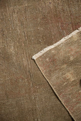 Distressed Turkish Sivas rug corner showing worn earthen pile, visible foundation, and fringe.