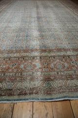 Distressed Tabriz carpet border detail, showing faded blues, terra cotta, and wear to foundation.
