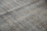 Distressed Tabriz carpet's intricate Herati pattern in pale blues and terra cotta.