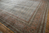 Distressed vintage Tabriz carpet showing wear across the intricate pale blue and blush Herati design.