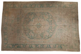 Vintage distressed Oushak carpet, large seafoam green medallion on a faded ivory field.
