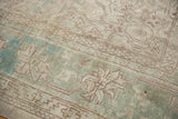 Muted ocean green and antique ivory palmette border, with vine motifs on distressed Oushak.