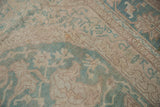 Distressed Oushak rug with even wear, featuring ocean green vine and palmette border.