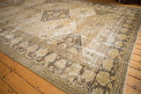 Vintage Persian Khorassan carpet's repeating diamond floral panels, time-softened ivory and gold.