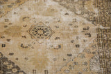 Distressed texture of a vintage Khorassan rug, with visible foundation, muted platinum and beige floral design.