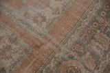 Distressed vintage Oushak carpet showing worn blush, beige, and oxidized silver tones.