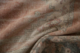 Distressed Oushak carpet's worn texture, exposed foundation, and muted blush, beige tones.