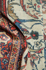 Hand-knotted vintage Mahal carpet detail: indigo blue vinery and lotus palmettes on madder root red and ivory.