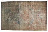 Distressed vintage Heriz carpet with a large central medallion and faded red, blue, ivory floral patterns.