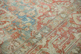 Distressed Heriz carpet detail with Rococo stylized floral relief in sky blue, faded red, and ivory.