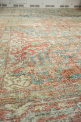 Distressed vintage Heriz carpet texture, showing faded red, sea foam green, and beige tones.