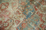 Distressed vintage Heriz carpet texture, showing wear and faded red, sky blue floral motifs.