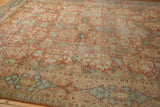 Worn terra cotta floral field and intricate denim blue border of a vintage Mahal rug.