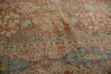 Angled detail of distressed Mahal carpet, with faded terra cotta, green, blue floral motifs, and soft texture.