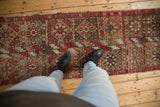 Vintage Oushak runner displaying red, brown, ivory floral geometric diamond medallions.
