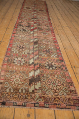 Vintage Oushak runner segment with floral geometric diamond medallions and barber pole motifs in red, blush, brown.