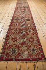 End of vintage Oushak runner, showing fringe and red, brown, ivory floral motifs.
