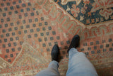 Distressed vintage Oushak rug, showing its softened pile, pale ruby red, and teal field motifs.