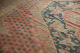 Vintage distressed Oushak carpet detail, showing even wear, time-softened blush, teal, and sand patterns.