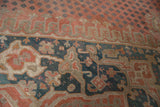 Distressed Oushak rug: dusty red field with mini plant motifs, muted teal border designs.