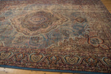 Detail of the vintage Malayer carpet's traditional floral border and blue machine binding.