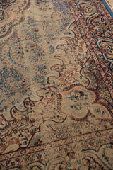 Vintage Persian Malayer carpet showing worn floral field and traditional border detail.