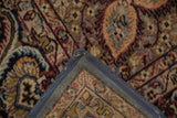 Vintage Malayer carpet corner detail, showing blue machine binding and rich floral motifs.