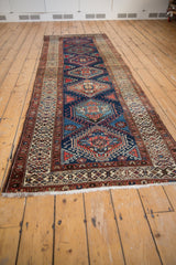 Close-up of vintage Northwest Persian runner's ivory hook-and-latch border and navy field.