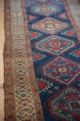 Northwest Persian runner's geometric border and field with hook-and-latch guls, navy, red, and ivory.