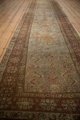 Distressed Heriz runner close-up, worn Herati motif on abrashed blue-green field with floral border.
