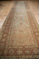 Geometric Herati motif on pale green field, rust floral border, showing even distressed wear.