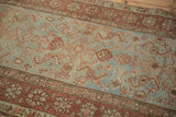 Distressed vintage Heriz runner showing abrashed pale blue ground, worn Herati motif, and muted rust tones.