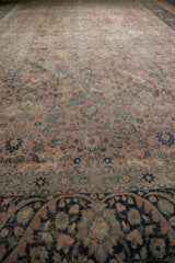 A low perspective across the distressed, low-pile floral field of a vintage Tabriz carpet.