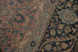 Evenly worn pile of a vintage Tabriz carpet, showing the raspberry field and navy blue floral border.