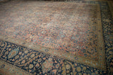 Angled view across the distressed Tabriz carpet showing the evenly worn pile texture.