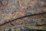 Soft folds reveal the worn texture and intricate floral pattern of a vintage Tabriz carpet.