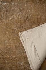 Back of distressed Afshar rug, showing visible hand-knotted foundation and stitched edge.