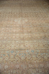 Low angle view across the worn, low pile of the vintage Tabriz carpet's abrashed Herati motif.