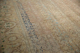 Distressed texture of a vintage Tabriz showing worn knot heads beside a detailed navy blue border.