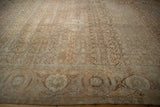 Time-softened tones and even wear across the Herati field of a vintage distressed Tabriz carpet.