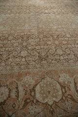 Low angle perspective across the time-softened, sandy pile of a vintage distressed Tabriz carpet.