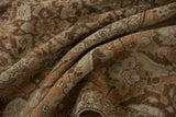 Softly folded vintage Tabriz showing the evenly worn, low pile in shades of sand and sandalwood.