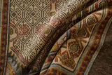 Folded vintage Serab rug with intricate geometric patterns and aged texture in ivory, burgundy, and blue.