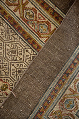 Close-up of the distressed Persian Serab runner's hand-knotted back and geometric pile.
