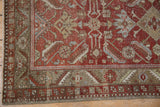Distressed vintage Heriz runner corner, olive green border, brick red Herati motif, visible wear.