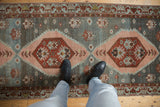 Distressed Malayer runner showing blush and wine serrated medallions on an abrash blue field.